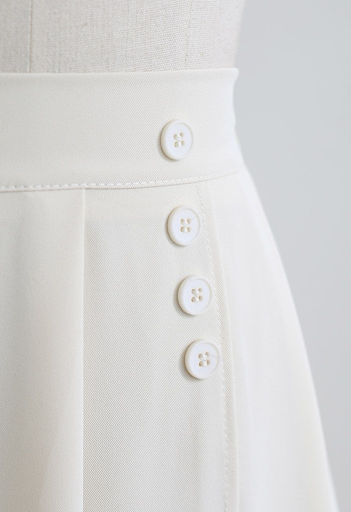 Saia plissada decorada com quatro botões em marfim